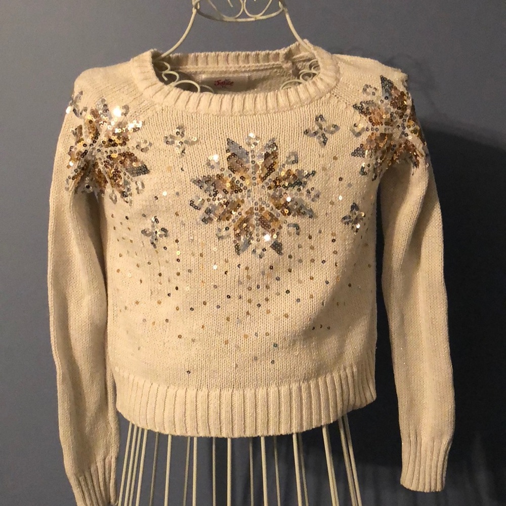 Justice sweater with gold and silver snowflakes.